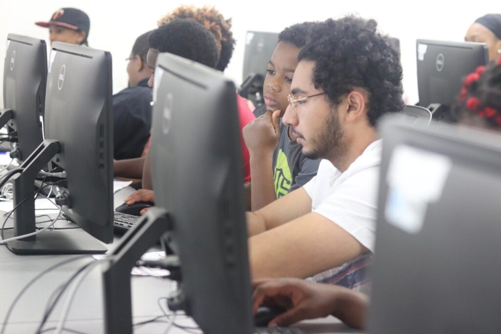 A child and an adult look at a computer screen together.