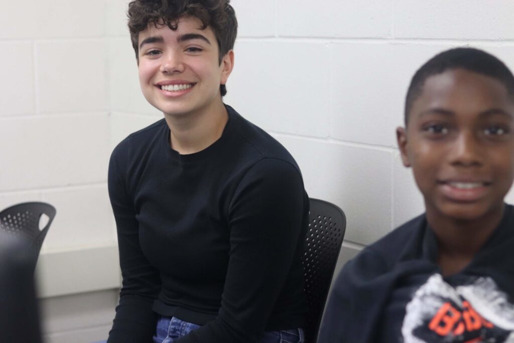 A child and a young woman smiling at the camera.